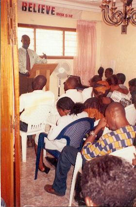 Pastor Obike John Okpabi sharing the Word of GOD on a sunday Service (July 2004).